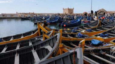 Essaouira, Marakeş, Fas - 15 Ağustos 2022: Mavi ve sarı balıkçı tekneli liman.