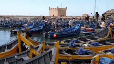 Essaouira, Marakeş, Fas - 15 Ağustos 2022: Mavi ve sarı balıkçı tekneli liman.