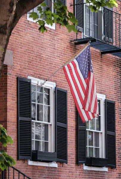 A US Flag Hanging Outside A Traditional Brownstone Townhouse In The Beacon Hill Area Of Boston