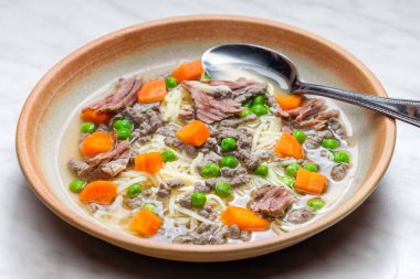 beef broth with green peas, carrot and small meatballs
