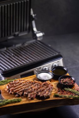 Tahtada pirzola, baharat ve elektrikli ızgara.