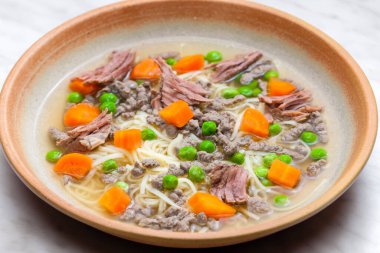 beef broth with green peas, carrot and small meatballs clipart