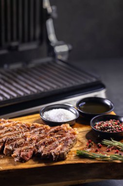 Tahtada pirzola, baharat ve elektrikli ızgara.