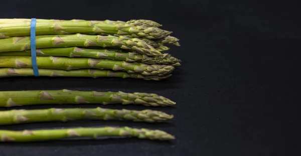 Stock image Green asparagus on black background