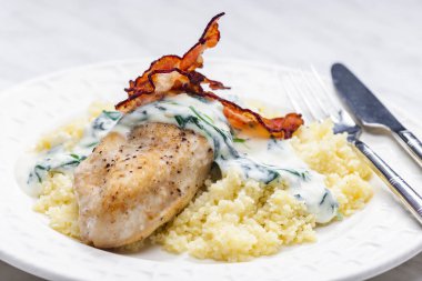 poultry breast with spinach creamy sauce and bacon served with couscous