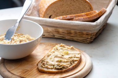 Çıtırtılar bir dilim ekmeğin üzerine salatalık turşusuyla yayılmış.