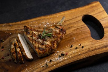 pork cutlet with a bone on rosemary and pepper