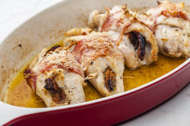 Domuz pastırmasında kurutulmuş domatesle doldurulmuş tavuk dürümü.