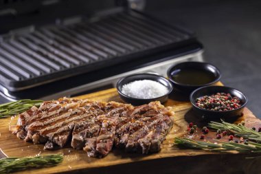 Tahtada pirzola, baharat ve elektrikli ızgara.