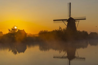 Hollanda 'nın Kinderdijk şehrinde güneş doğmadan hemen önce renkli gökyüzü olan geleneksel Hollanda yel değirmenleri
