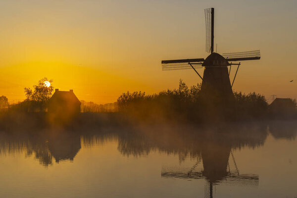 Traditional Dutch windmills with a colourful sky just before sunrise in Kinderdijk, The Netherlands