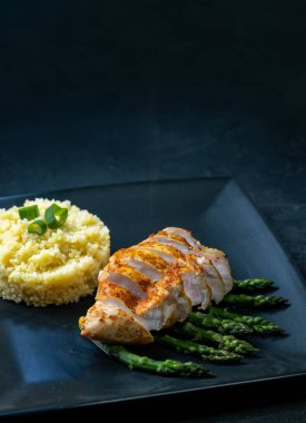 Izgara tavuk fileto ve kuskus ile birlikte yeşil kuşkonmaz. 