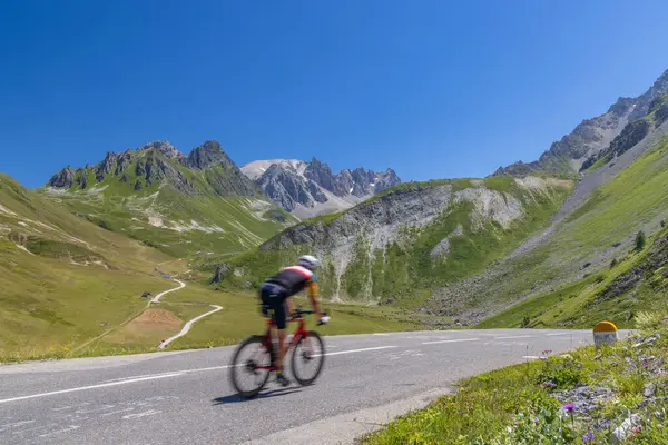 法国上阿尔卑斯省Col Galibier附近大阿尔卑斯山脉沿线的骑自行车者 图库图片