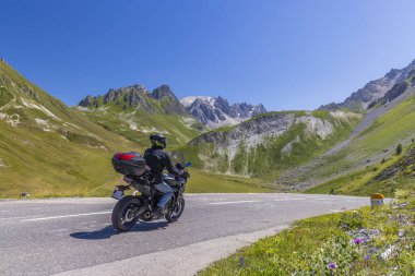 Col du Galibier, Hautes-Alpes, Fransa yakınlarındaki Grandes Alpes yolunda motosiklet.
