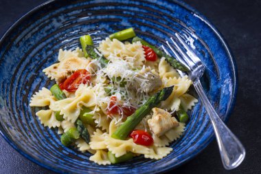 Yeşil kuşkonmaz, vişneli domates ve tavuklu Farfalle makarna.