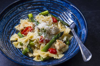 Yeşil kuşkonmaz, vişneli domates ve tavuklu Farfalle makarna.