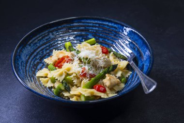 Yeşil kuşkonmaz, vişneli domates ve tavuklu Farfalle makarna.