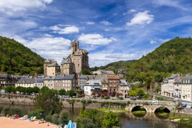 Heybetli şatosu ve Fransa, Aveyron 'da taş bir köprünün altından akan nehir manzarası.
