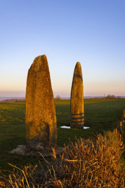 Güzel bir günbatımında, bir tarlada duran iki menhir, Kanepeler, Saone et Loire, Bourgogne Franche Comte, Fransa
