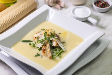 Lezzetli kremalı patates çorbası ızgara tavuk göğsü, parmesan talaşı ve taze roka ile süslenir.