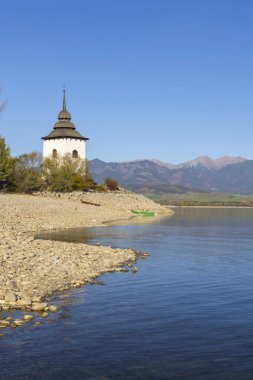 Liptovska Mara Gölü manzaralı sel basmış köyün kilise kulesi ve arka planda Batı Tatra, Slovakya