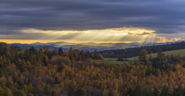 Low Tatras ile birlikte renkli sonbahar ormanları üzerinde parlayan güneş ışınları