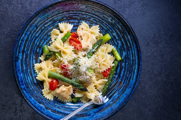Yeşil kuşkonmaz, vişneli domates ve tavuklu Farfalle makarna.