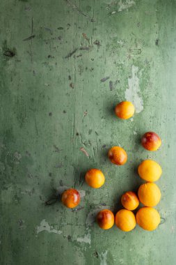 Dokulu yeşil ahşap bir masaya yerleştirilmiş canlı portakallar, kopya alanı ile görsel olarak çekici bir tasarım yaratıyor.