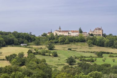 Fransa, Lot 'taki Dordogne Vadisi' ne bakan Ortaçağ Şatosu ve Loubressac Kilisesi bulutlu gökyüzünün altında.