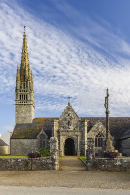 Notre Dame de la Clarte Kilisesi Beuzec Cap Sizun, Finistere, Brittany 'de bulutlu bir gökyüzüne doğru yükselen etkileyici çan kulesiyle