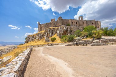 Calatrava la Nueva Şatosu, Aldea del Rey, Ciudad Real, Kastilya La Mancha, İspanya yakınlarındaki bir ortaçağ kalesi, parlak mavi bir gökyüzü altında görkemli bir şekilde yükseliyor.