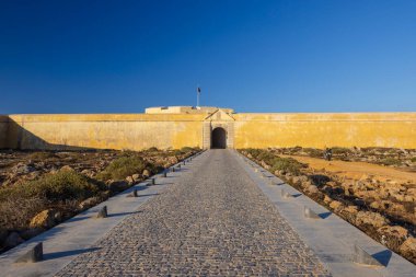 Vila do Bispo, Algarve, Portekiz 'in önde gelen tarihi simgelerinden biri olan Fortaleza de Sagres' e giden kaldırım taşı yolu altın güneş ışığıyla yıkandı.
