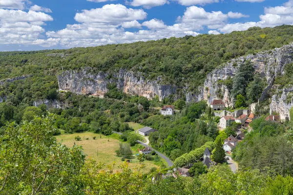 Saint Sulpice 'in panoramik manzarası, Fransa' nın Lot bölgesindeki kayalıkların ve yemyeşil bitkilerin arasına yerleşmiştir.