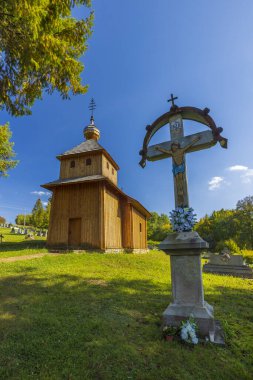 Smigovec, Presovsky Kraj, Slovakya 'da mezarlığı ve haçı olan geleneksel tahta Aziz Mikail Kilisesi
