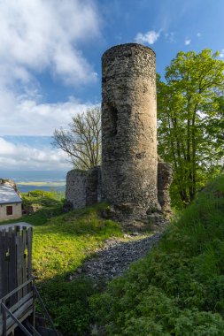 Kostomlaty kapsülü Milesovkou Şatosu 'nun antik taş kulesi, Ustecky Kraj, parlak mavi gökyüzüne karşı yükselir.