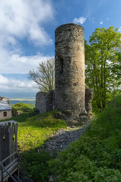 Kostomlaty kapsülü Milesovkou Şatosu 'nun antik taş kulesi, Ustecky Kraj, parlak mavi gökyüzüne karşı yükselir.