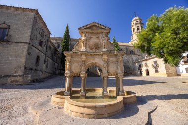 Arka planda Baeza Katedrali, Endülüs 'ün Baeza şehrinde güneşli bir yaz günü, Santa Maria Meydanı' nda su sıçratan Rönesans çeşmesi.