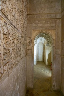 Karmaşık oymalar, Alhambra 'nın kemerli kapısından geçen ve Fas mimarisini gözler önüne seren bir geçitin duvarlarını süslüyor.