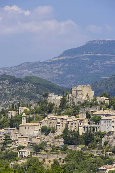 Montbrun les Bains 'in ortaçağ mimarisi ve çarpıcı doğal çevresini gözler önüne sererek Drome Vadisi' ndeki bir tepenin üzerine tünemiş resimli görüntüsü.