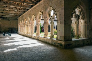 La Romieu, Occitanie 'deki St. Pierre Kolej Kilisesi' nin aydınlatma manastırı güzel gölgeler yaratıyor.