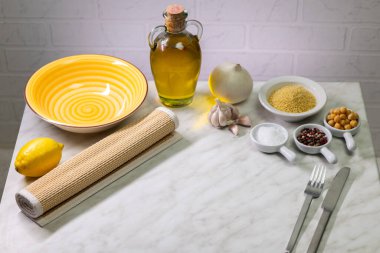 Misket masasında nohut, limon, sarımsak ve soğanlı vejetaryen kuskus hazırlamak için gerekli malzemeler.