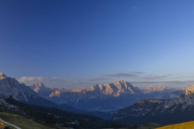 Dolomitlerin panoramik manzarası yazın açık mavi gökyüzüyle gün doğumunda parlıyordu.