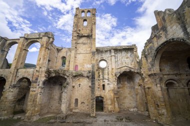 Alet les Bains, Aude, Occitanie, Fransa 'daki Saint Marie Manastırı' nın kalıntılarının alçak açılı görüntüsü mavi gökyüzünün arka planına karşı mimari kalıntıları vurguluyor.