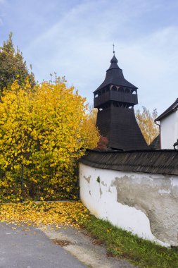Güzel bir sonbahar gününde Slovakya 'nın Stara Halic kentinde duran ayrı ahşap çan kulesiyle Antakyalı Aziz Margaret Kilisesi.