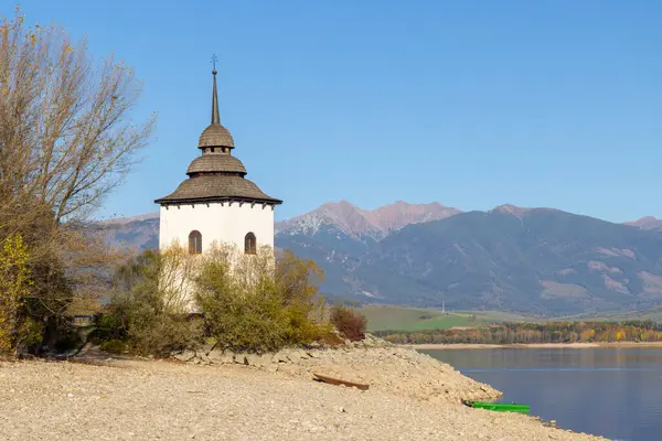 Liptovska Mara Gölü manzaralı sel basmış köyün kilise kulesi ve arka planda Batı Tatra, Slovakya