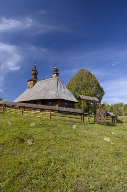 Hrabova Roztoka, Presovsky Kraj, Slovakya 'daki geleneksel ahşap kilise mavi gökyüzüne karşı eşsiz mimarisini sergiliyor.