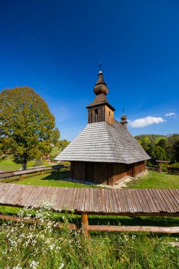 Hrabova Roztoka, Presovsky Kraj, Slovakya 'da kiremitli ahşap kilisesi güneşli bir günde güneşle yıkandı.