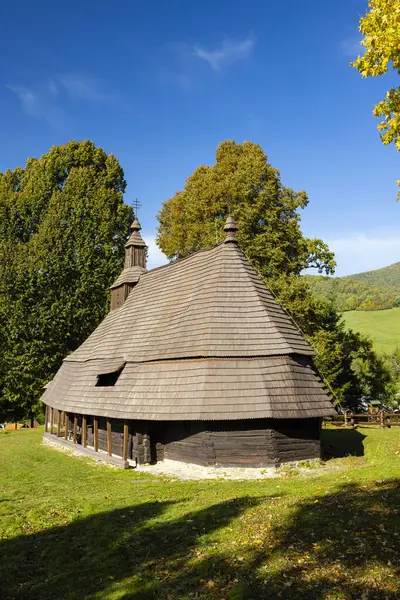 Slovakya 'nın Topola kentindeki geleneksel ahşap kilise, kiremit çatılı ve renkli sonbahar yapraklarıyla çevrili.