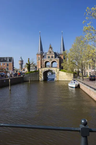 Sneek, Friesland 'daki ikonik Waterpoort kapısının manzarası güneşli bir günde kanalda yelken açan bir tekne.