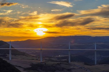 Etkileyici kablo köprü olarak kaldı, Millau Viaduct, Güney Fransa 'daki Tarn Vadisi' nin üzerinde canlı bir günbatımına karşı dimdik duruyordu.